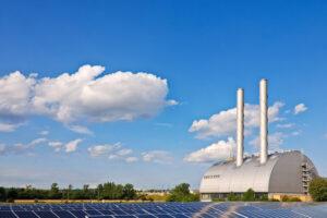 Kraftwerk mit Solarzellen im Vordergrund