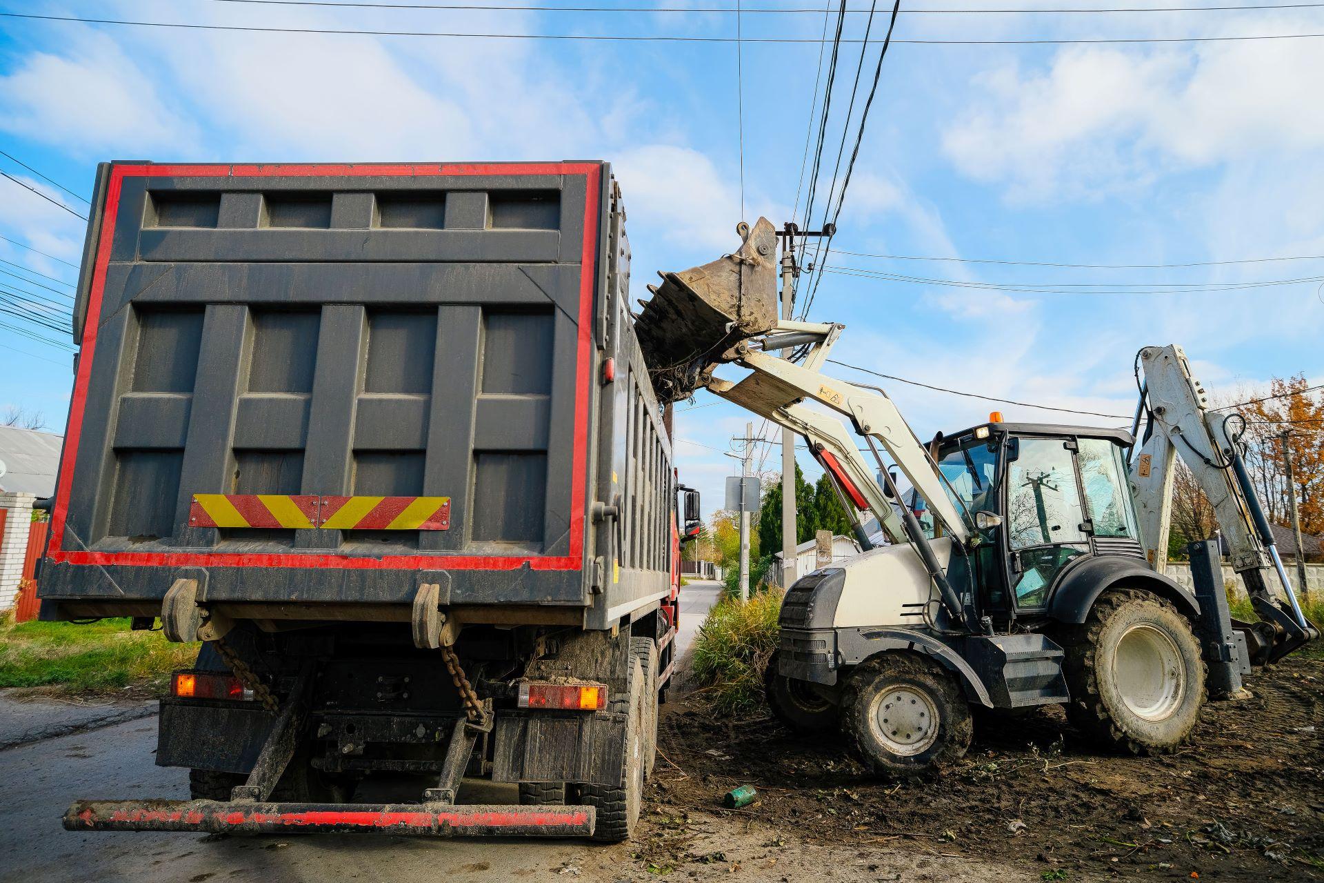 Bagger lädt Abfälle in offenen LKW
